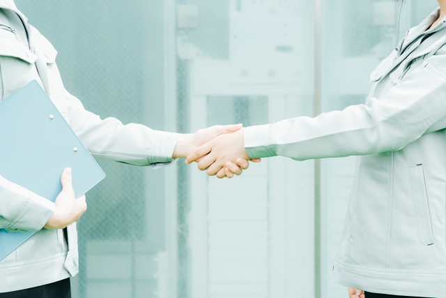 握手する作業服を着た職人